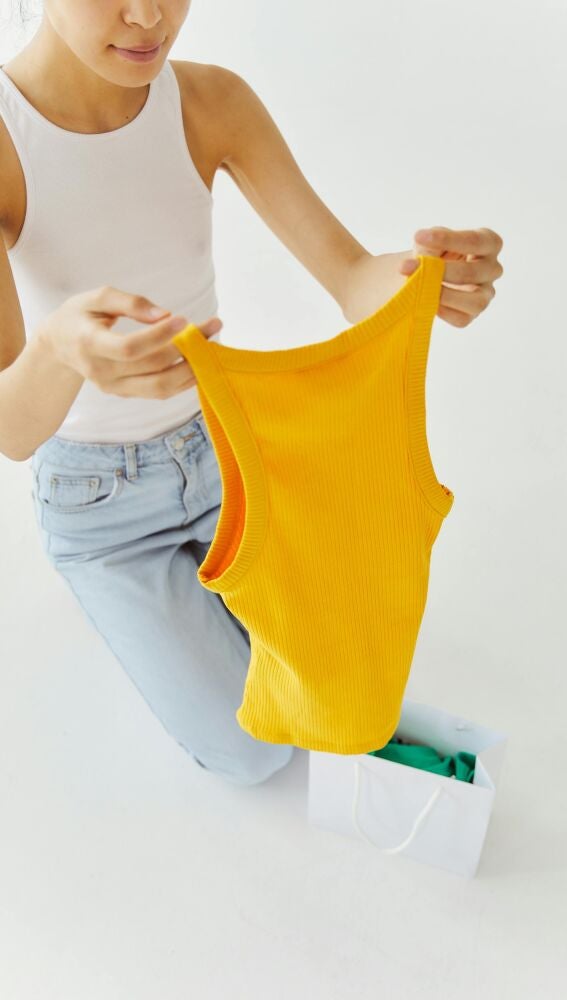 Mujer que se ha comprado camisetas básicas de tirantes de colores