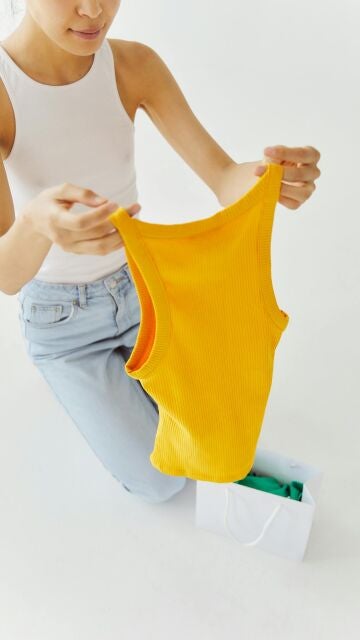 Mujer que se ha comprado camisetas básicas de tirantes de colores