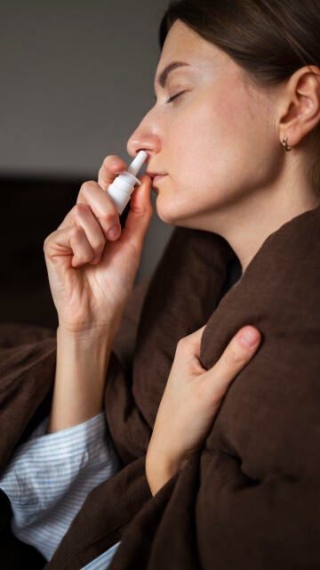 Mujer usando un espray nasal