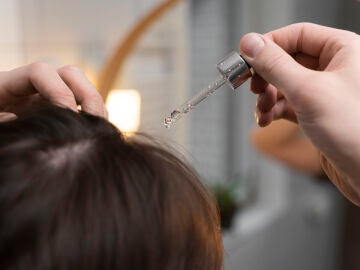 Mujer cuid&aacute;ndose el cabello