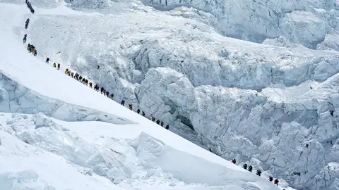 Una hilera de escaladores rumbo a la cima del Everest Una hilera de escaladores rumbo a la cima del Everest