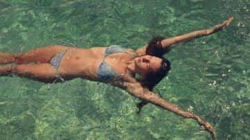 Mujer en bikini ba&ntilde;&aacute;ndose en la playa