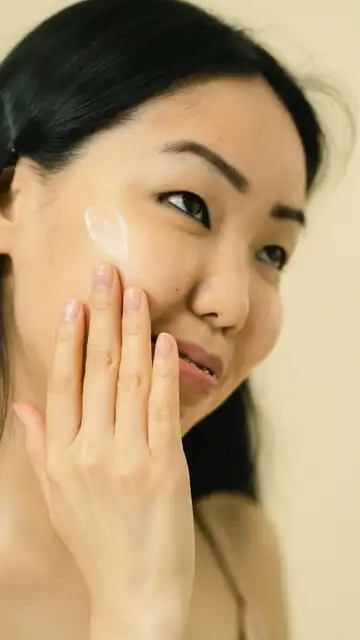Mujer poniéndose crema solar en el rostro Mujer poniéndose crema solar en el rostro