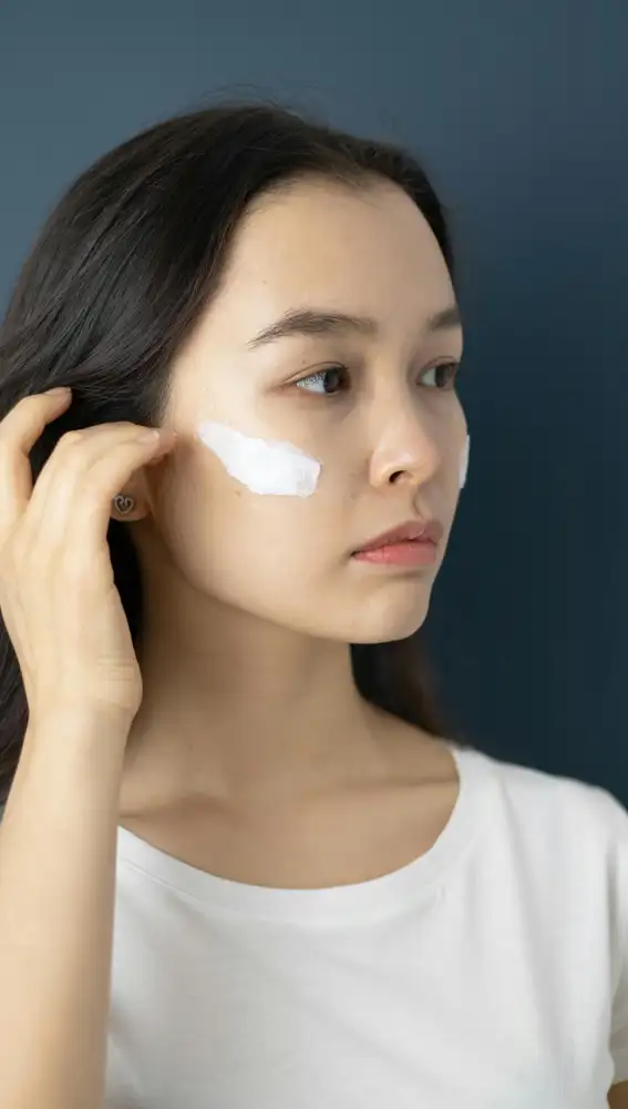 Mujer poniéndose crema solar en el rostro Mujer poniéndose crema solar en el rostro