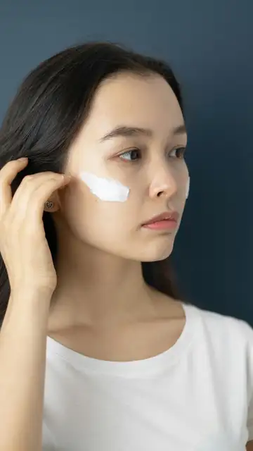 Mujer poniéndose crema solar en el rostro Mujer poniéndose crema solar en el rostro