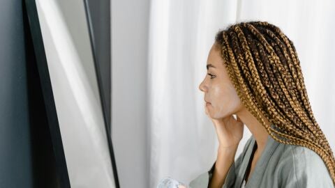 Mujer poniéndose crema solar en el rostro