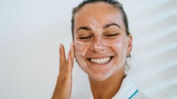 Mujer poni&eacute;ndose crema solar en el rostro