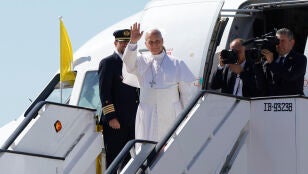 El papa Le&oacute;n XIV saluda mientras sube abordo del avi&oacute;n.