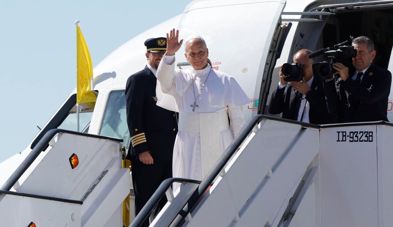 El papa Le&oacute;n XIV saluda mientras sube abordo del avi&oacute;n.