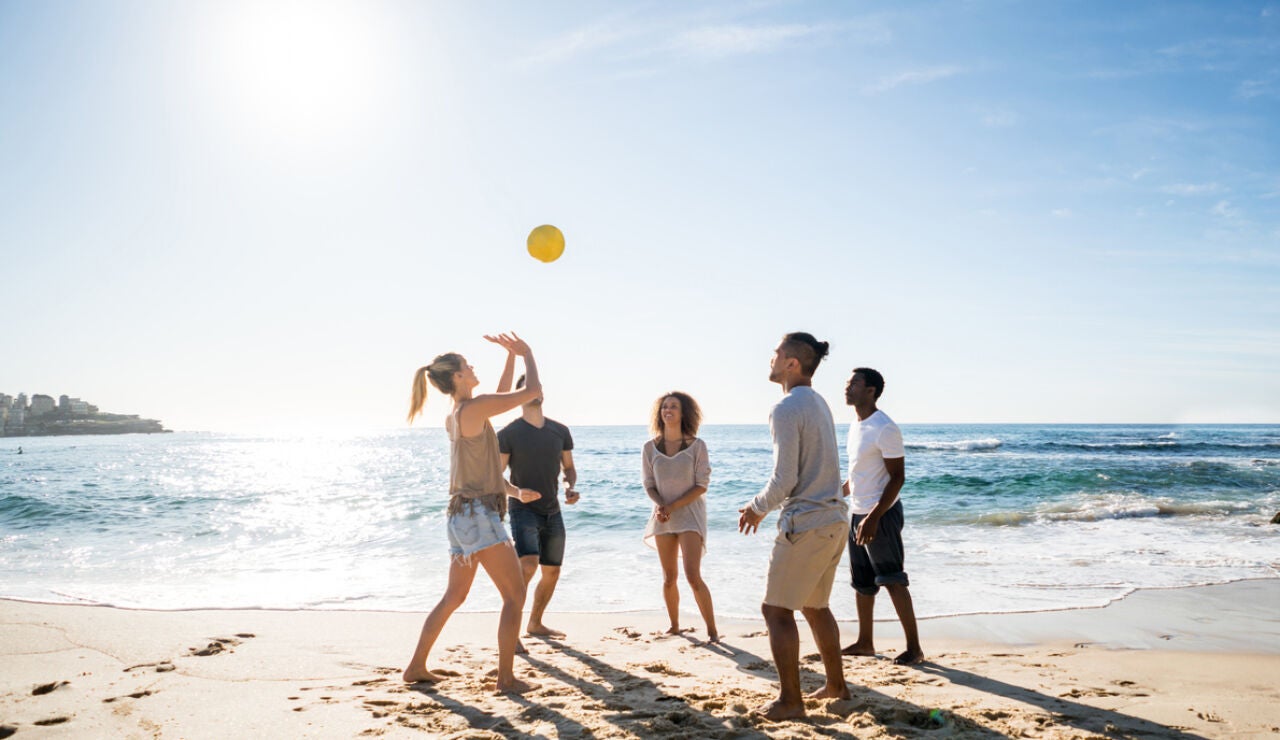 Jugando con un bal&oacute;n en la playa