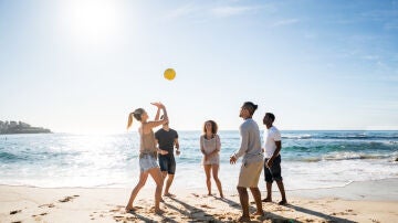 Jugando con un bal&oacute;n en la playa