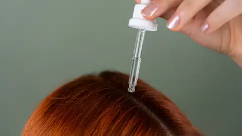 Mujer tratándose el cabello Mujer tratándose el cabello