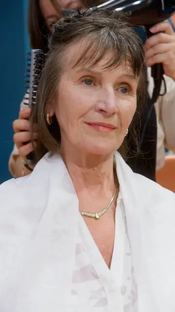 Mujer mayor tratándose el cabello Mujer mayor tratándose el cabello