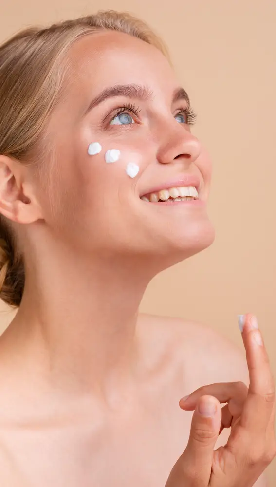 Mujer aplicándose crema solar facial Mujer aplicándose crema solar facial
