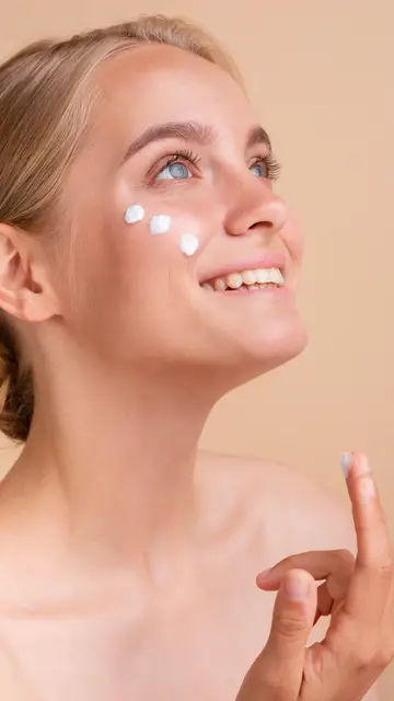 Mujer aplicándose crema solar facial Mujer aplicándose crema solar facial
