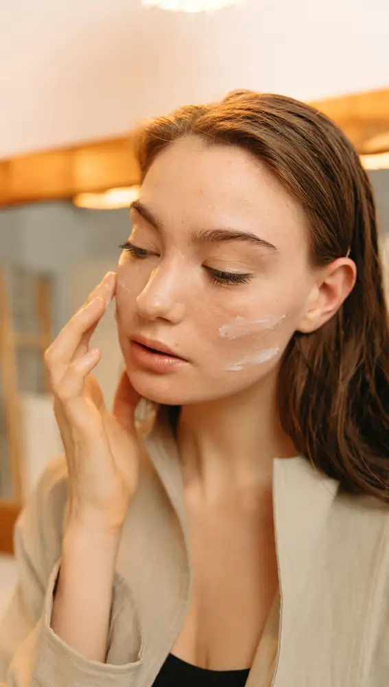 Mujer aplicándose crema solar facial Mujer aplicándose crema solar facial