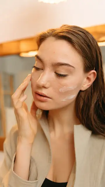 Mujer aplicándose crema solar facial Mujer aplicándose crema solar facial