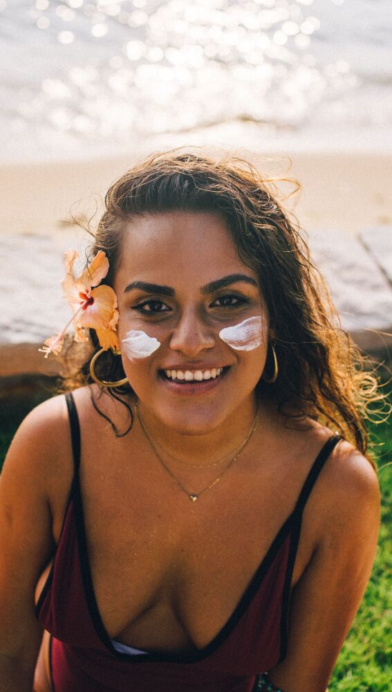 Mujer aplicándose crema solar facial