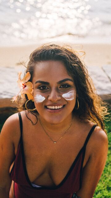 Mujer aplicándose crema solar facial