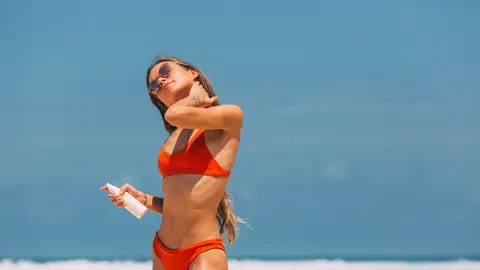 Mujer aplicándose crema solar en el cuello Mujer aplicándose crema solar en el cuello