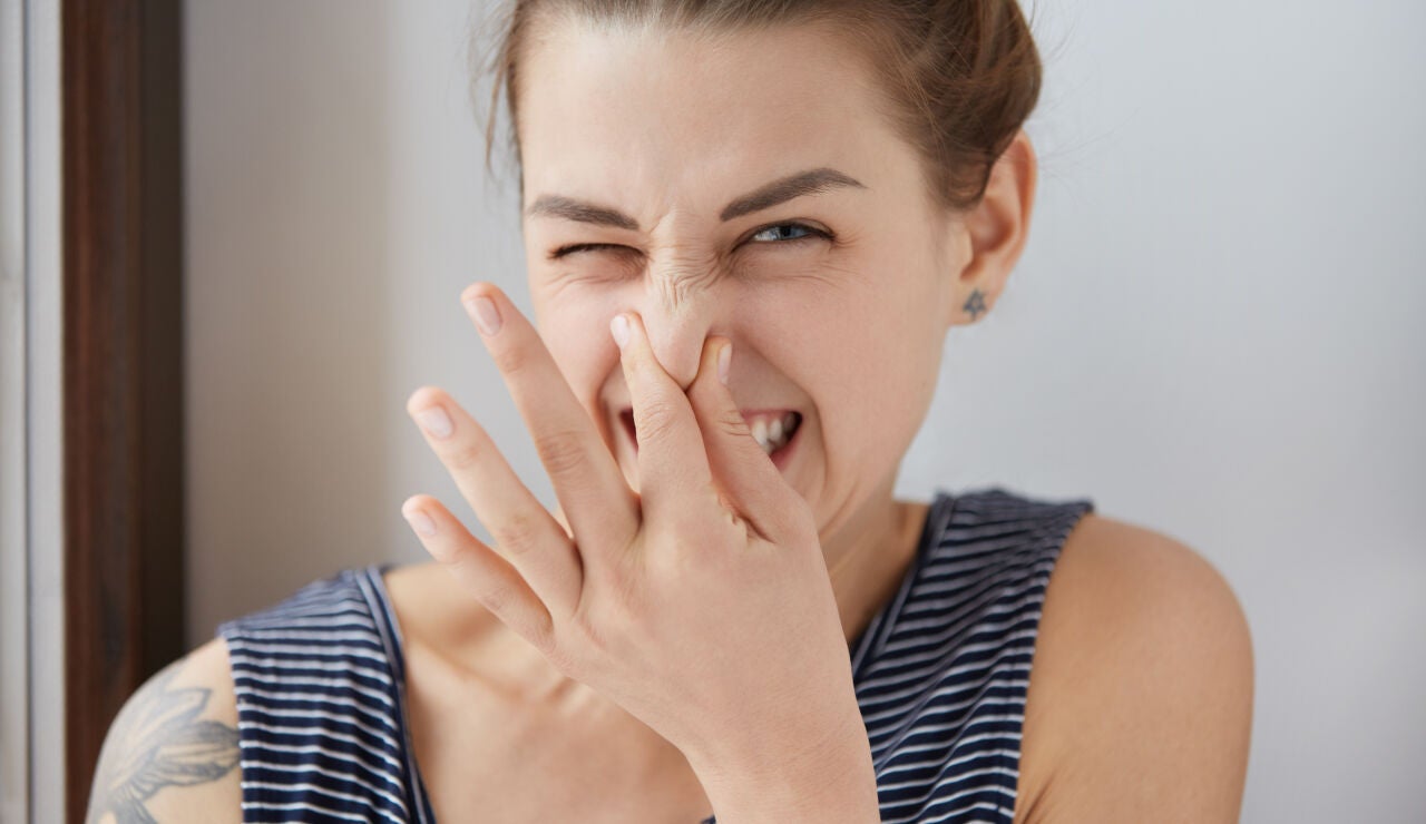 Mujer tap&aacute;ndose la nariz por el mal olor