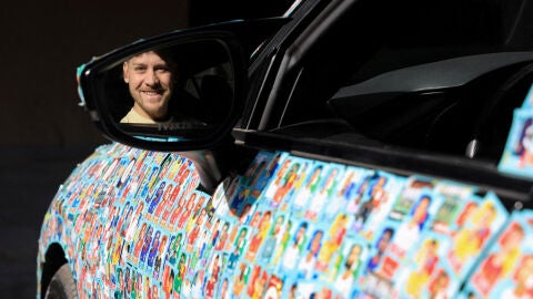 Ariel Osses subido a su coche con los cromos del Mundial