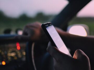 Imagen de un conductor con el m&oacute;vil en la mano 