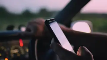 Imagen de un conductor con el móvil en la mano Imagen de un conductor con el móvil en la mano