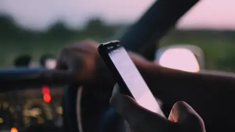 Imagen de un conductor con el móvil en la mano Imagen de un conductor con el móvil en la mano