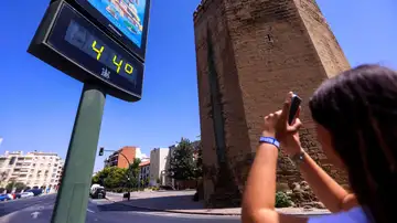Imagen de una mujer haciendo una foto al termómetro de la calle en Córdoba Imagen de una mujer haciendo una foto al termómetro de la calle en Córdoba