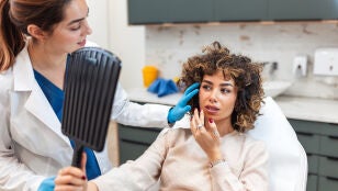 Mujer mirando su cara despu&eacute;s de un tratamiento de belleza