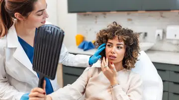 Mujer mirando su cara después de un tratamiento de belleza Mujer mirando su cara después de un tratamiento de belleza
