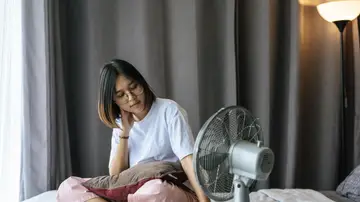 Mujer usando un ventilador Mujer usando un ventilador