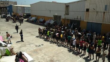 Unos migrantes llegan a un punto de distribuci&oacute;n de alimentos gestionado por Luna Blanca, una ONG con sede en Ceuta.