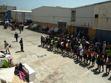 Unos migrantes llegan a un punto de distribuci&oacute;n de alimentos gestionado por Luna Blanca, una ONG con sede en Ceuta.