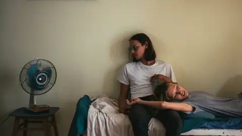 Pareja usando un ventilador Pareja usando un ventilador