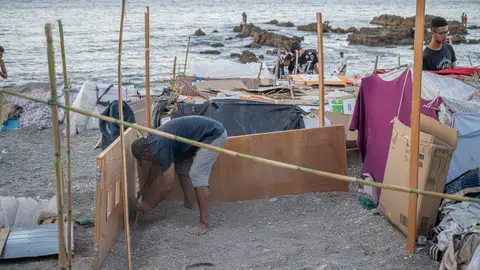 La playa del Trampolín vuelve a presentar el mismo aspecto que durante los primeros días de la llegada masiva de migrantes Decenas de personas viven y pernoctan en la playa del Trampolín, a 28 de agosto de 2026, en Ceuta (España). En la zona de la playa del Trampolín permanecen aún cientos de migrantes en situación irregular, donde han vuelto a construir chozas. 28 AGOSTO 2026 CRISIS MIGRATORIA Marcos Moreno / Europa Press 28/08/2026