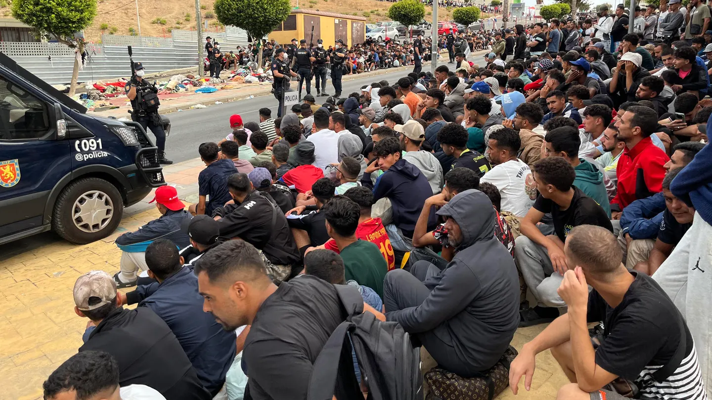 Migrantes frente a la explanada de embotellamiento de Loma Colmenar Migrantes frente a la explanada de embotellamiento de Loma Colmenar