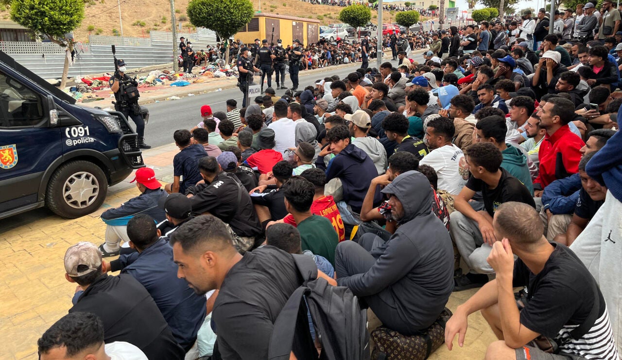  Migrantes frente a la explanada de embotellamiento de Loma Colmenar