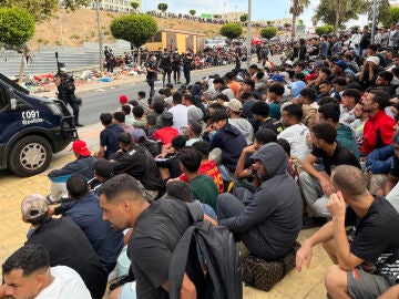  Migrantes frente a la explanada de embotellamiento de Loma Colmenar