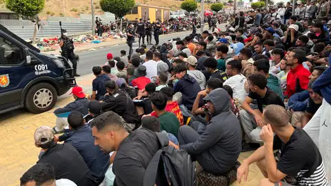 Migrantes frente a la explanada de embotellamiento de Loma Colmenar Migrantes frente a la explanada de embotellamiento de Loma Colmenar