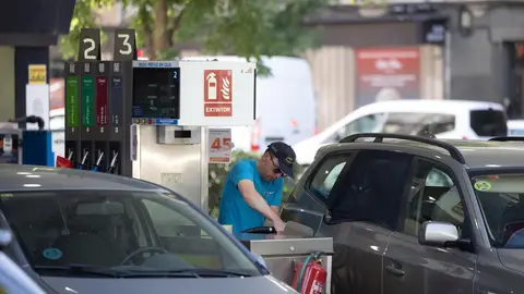 Una persona reposta el combustible de su coche en una gasolinera Una persona reposta el combustible de su coche en una gasolinera