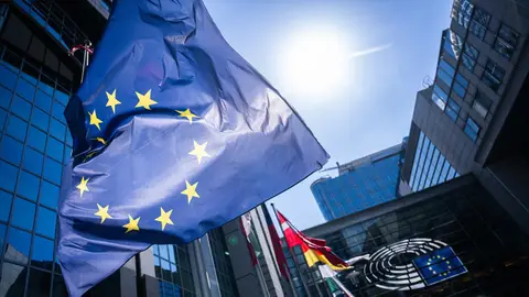 Bandera de la Unión Europea frente al edificio del Parlamento Europeo en Bruselas Bandera de la Unión Europea frente al edificio del Parlamento Europeo en Bruselas