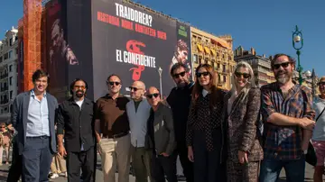 El equipo de El confidente junto al cartel de la película El equipo de El confidente junto al cartel de la película