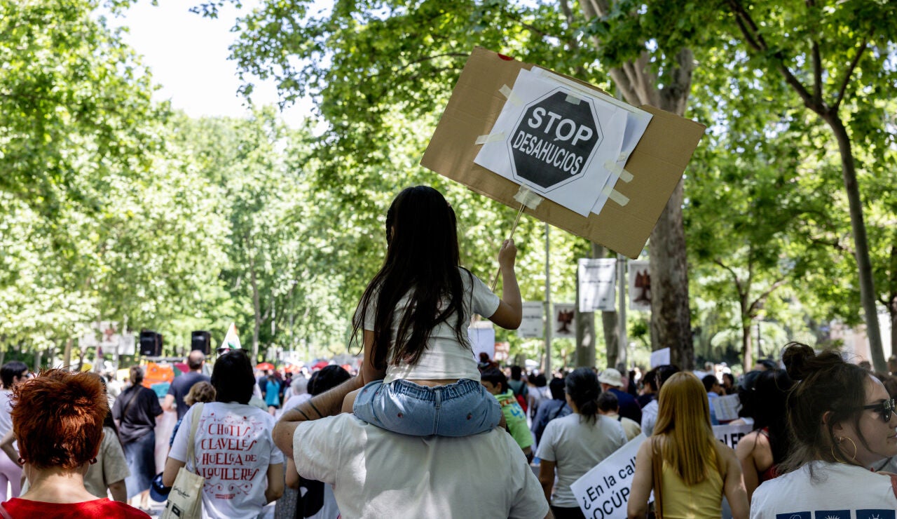 Manifestantes portan pancarta con lema 'Stop desahucios' durante una manifestaci&oacute;n en defensa del derecho al acceso a la vivienda, a 24 de mayo de 2026,