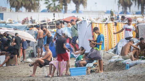 Varios migrantes acampados en la playa del Trampol&iacute;n, a 23 de septiembre de 2026, en Ceuta (Espa&ntilde;a). Embarcaciones de Salvamento Mar&iacute;timo han trabajado este mi&eacute;rcoles en la reparaci&oacute;n de desperfectos detectados en la barrera neum&aacute;tica instalada en el entorno fronterizo del Tarajal en Ceuta, despu&eacute;s de que distintos m&oacute;dulos de la estructura hayan vuelto a perder presi&oacute;n y presenten un aspecto parcialmente desinflado.
23 SEPTIEMBRE 2026;MIGRANTES;CRISIS;INVASORES;COLCHONETA;INMIGRACI&Oacute;N;CRISIS;...