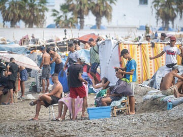 Varios migrantes acampados en la playa del Trampol&iacute;n, a 23 de septiembre de 2026, en Ceuta (Espa&ntilde;a). Embarcaciones de Salvamento Mar&iacute;timo han trabajado este mi&eacute;rcoles en la reparaci&oacute;n de desperfectos detectados en la barrera neum&aacute;tica instalada en el entorno fronterizo del Tarajal en Ceuta, despu&eacute;s de que distintos m&oacute;dulos de la estructura hayan vuelto a perder presi&oacute;n y presenten un aspecto parcialmente desinflado. 23 SEPTIEMBRE 2026;MIGRANTES;CRISIS;INVASORES;COLCHONETA;INMIGRACI&Oacute;N;CRISIS;...