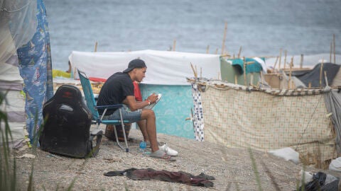 Un migrante acampado en la playa de Ben&iacute;tez, a 23 de septiembre de 2026, en Ceuta (Espa&ntilde;a). Embarcaciones de Salvamento Mar&iacute;timo han trabajado este mi&eacute;rcoles en la reparaci&oacute;n de desperfectos detectados en la barrera neum&aacute;tica instalada en el entorno fronterizo del Tarajal en Ceuta, despu&eacute;s de que distintos m&oacute;dulos de la estructura hayan vuelto a perder presi&oacute;n y presenten un aspecto parcialmente desinflado. 23 SEPTIEMBRE 2026;MIGRANTES;CRISIS;INVASORES;COLCHONETA;INMIGRACI&Oacute;N;CRISIS;POLIC&Iacute;A; ...
