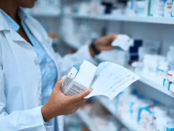 Imagen de un farmacéutico cogiendo medicamentos Imagen de un farmacéutico cogiendo medicamentos
