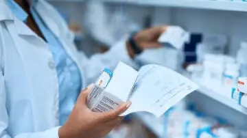 Imagen de un farmacéutico cogiendo medicamentos Imagen de un farmacéutico cogiendo medicamentos